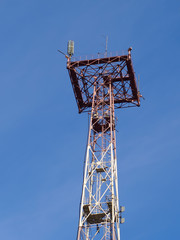 
top part of communication tower with antennas closeup on blue  sky