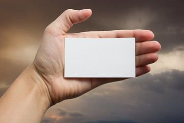 Hand holding white business card on blurred background