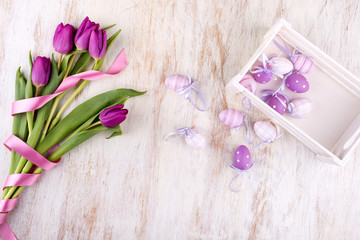 easter eggs and flowers over white wooden table