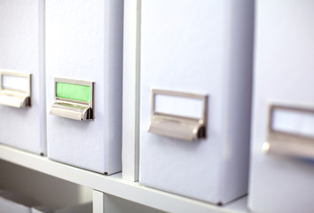File folders, standing on  shelves in the background