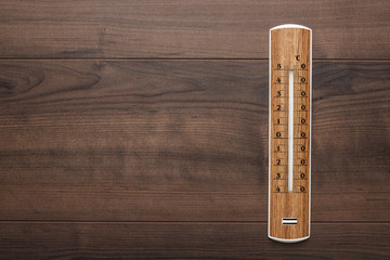 wooden thermometer on the brown table background
