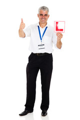senior driving instructor holding L sign
