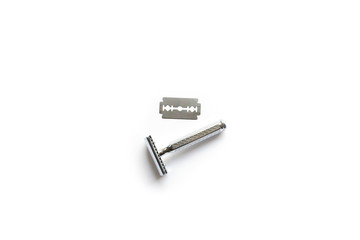 vintage chrome plated razor with a blade on a white background seen from above