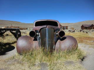 Grill of rusty old car in ghost town of Bodie, California - landscape color photo
