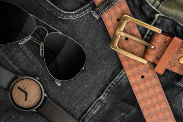 Various fashions of sunglasses, wrist watches and belt in jeans