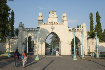 Portal de piedra a tres arcos con mujeres de espalda en las calle de la ciudad de Surakarta, Java Indonesia