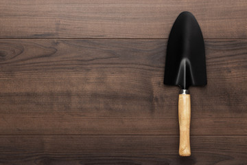 black gardening shovel on the wooden table with copy space © Ruslan Grumble
