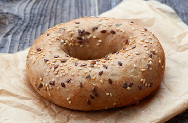 Fullgrain bagel with seeds on wooden table