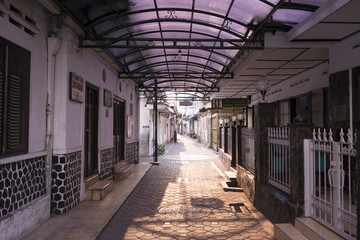 Calle estrechas de la ciudad de Surakarta con hombre empujando una carreta, Java Indonesia