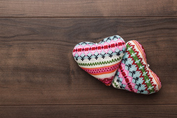 two knitted heart shapes on the wooden table