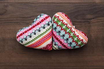 two knitted heart shapes on the wooden table