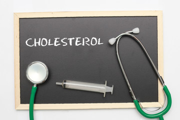 CHOLESTEROL concept with stethoscope and syringe