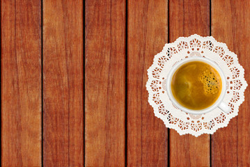 white coffee cup on lace cloth on wooden background
