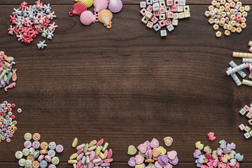 different colorful beads on the brown wooden table with copy space