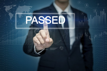 Obraz premium Businessman hand touching PASSED button on virtual screen