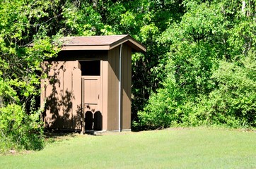 Brown outhouse used for rustic camping