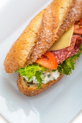 long sandwich with ham, cheese, tomatoes and lettuce. Isolated on white background