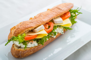 long sandwich with tofu, cheese, tomatoes and lettuce. Isolated on white background