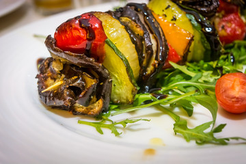 Hot vegetarian shashlik with courgette, aubergine, onion, red pepper and arugula