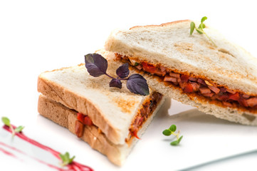 toast sandwich with ham, tomatoes on white plate, isolated on white background