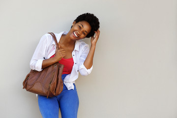 Smiling young african woman with a bag