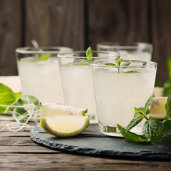 Fresh cocktail with lemon, ice and mint on the vintage table