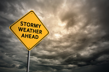 Sign with words 'Stormy weather ahead' and thunderclouds