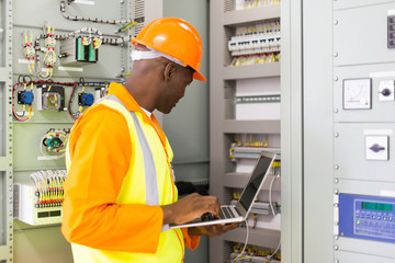 african american industrial engineer checking computerized machi