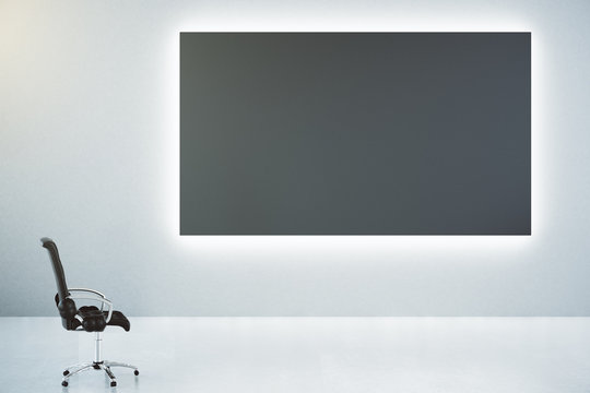 Blank black poster on white wall and classic leather chair, mock