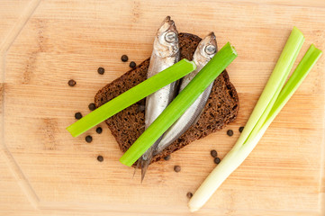 Salted sprats on wooden board