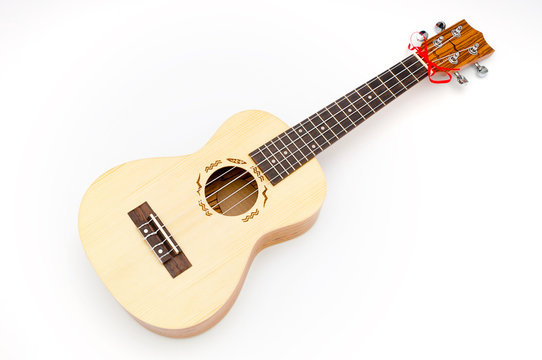 Hawaiian four stringed ukulele guitar on white background
