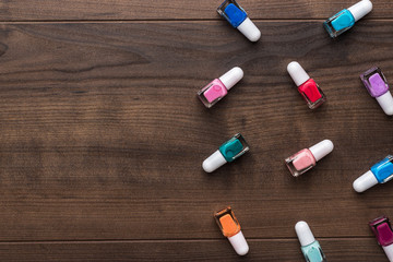 nail polish bottles of different colors on brown wooden table