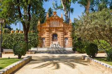 Fototapeta premium Beautiful fontain in the Alcazar fortress wall. Monument Catalina Ribeira, tiled portrait and Seville Ladies