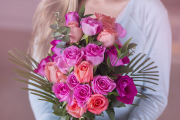 Woman holding a bouquet of beautiful pink roses