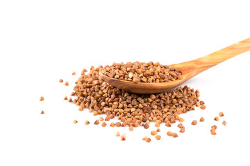 Uncooked buckwheat on wooden spoon