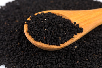 Heap of black sesame on wooden spoon