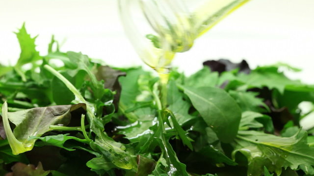 Pouring oil into salad