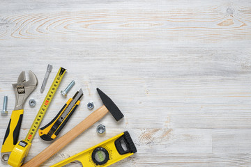 Top view of construction instruments and tools on wooden DIY workbench. with open space. Level, tape measure, wrench, hammer, cutter.
