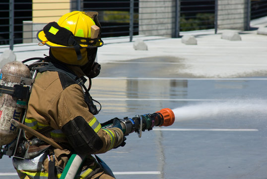 Firefighters training for fire with water hose