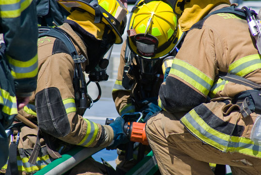 Firefighters training for fire with water hose