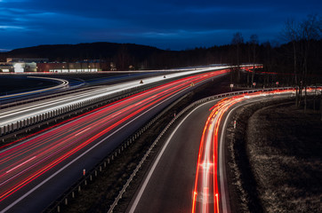 white and red car light trails on motorway junction