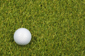 Golf ball on course with green grass.
