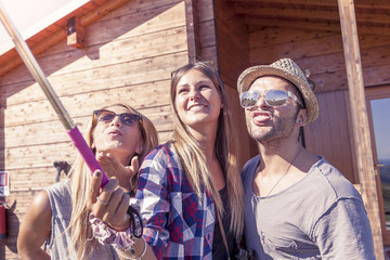 group of smiling friends taking funny selfie with smart phone