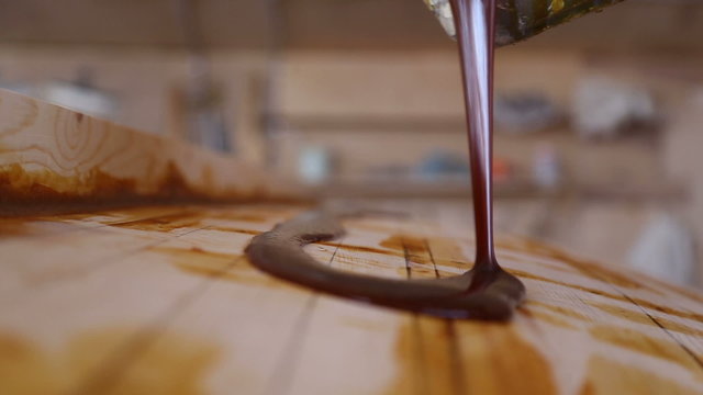 Construction of boats at the shipyard, the carpenter pours resin on the boat for bonding fiberglass
