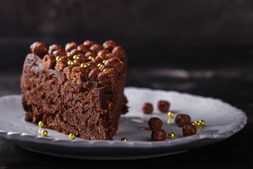 Piece of chocolate cake  on a dark background.