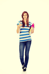 Young smiling teenage woman holding books
