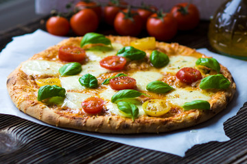 Homemade pizza with mozzarella, cherry tomatoes and Basil
