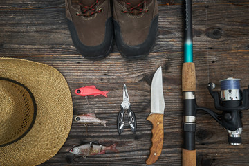 fishing tackles and fishing gear on wooden background