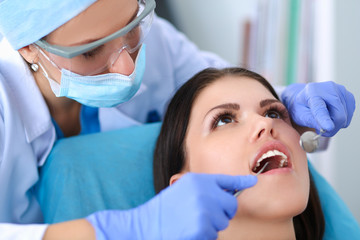 Woman dentist working at her patients teeth
