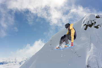 Flying snowboarder on mountains. Extreme sport.
